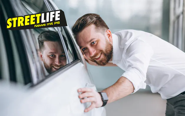 Mann streichelt Auto