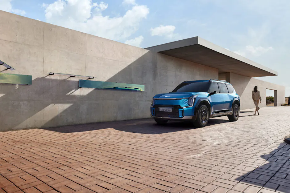 Kia EV9 GT-Line in Blau vor einer Betonwand