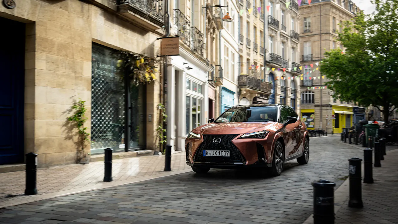 La Lexus UX 300h brune se déplace dans une ville