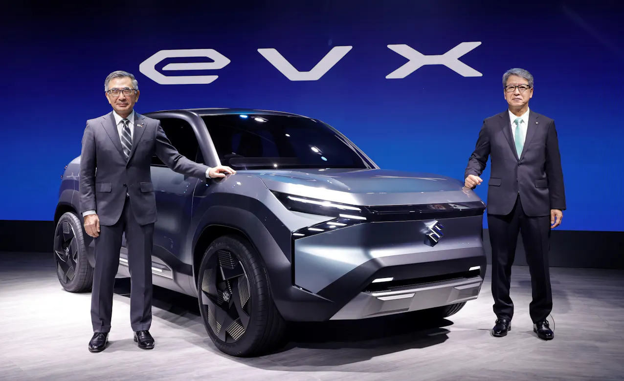 Suzuki EVX di colore argento, due uomini in giacca e cravatta accanto all'auto