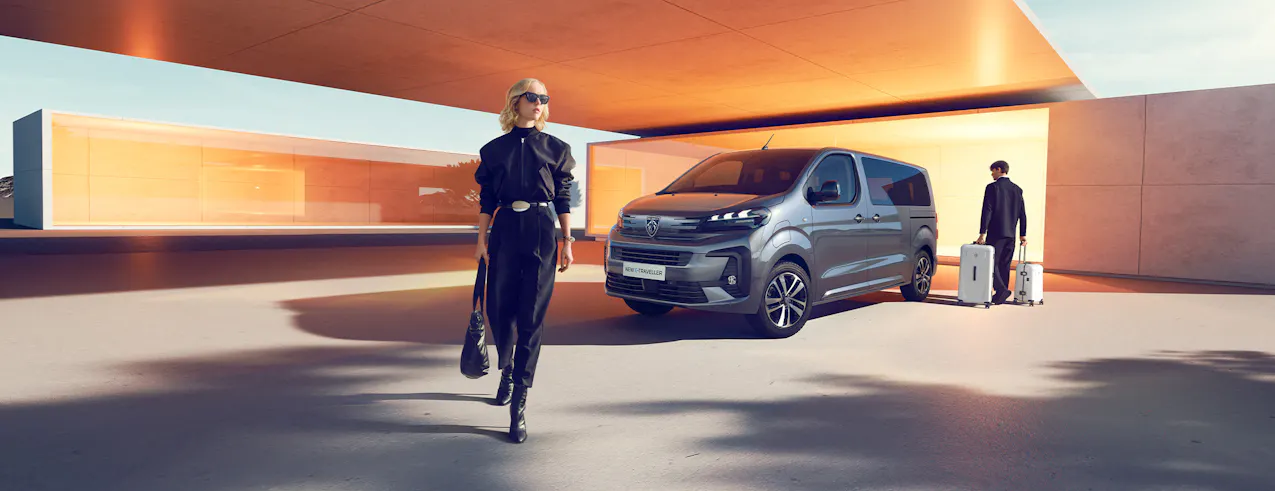 Dame avec sac de voyage et Peugeot E-Traveller en arrière-plan