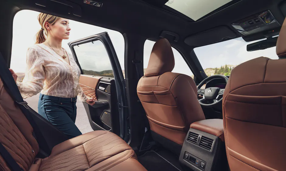 Mitsubishi Outlander sedile posteriore a panchina, sedili in pelle marrone, la signora sale
