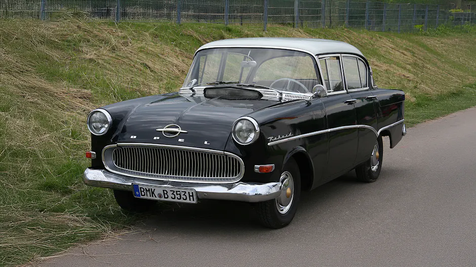 Opel Rekord nera con tetto argentato, prato verde sullo sfondo