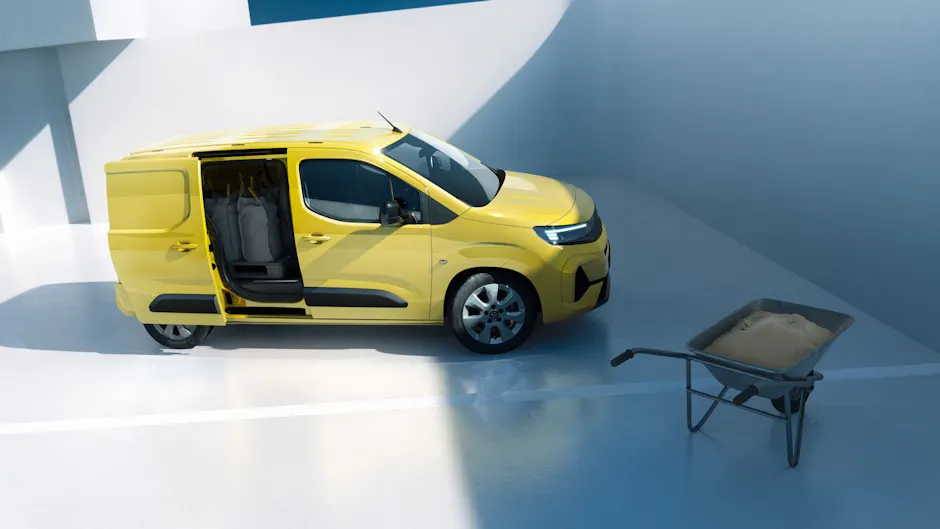 Opel Combo Cargo chargé en jaune, brouette au premier plan