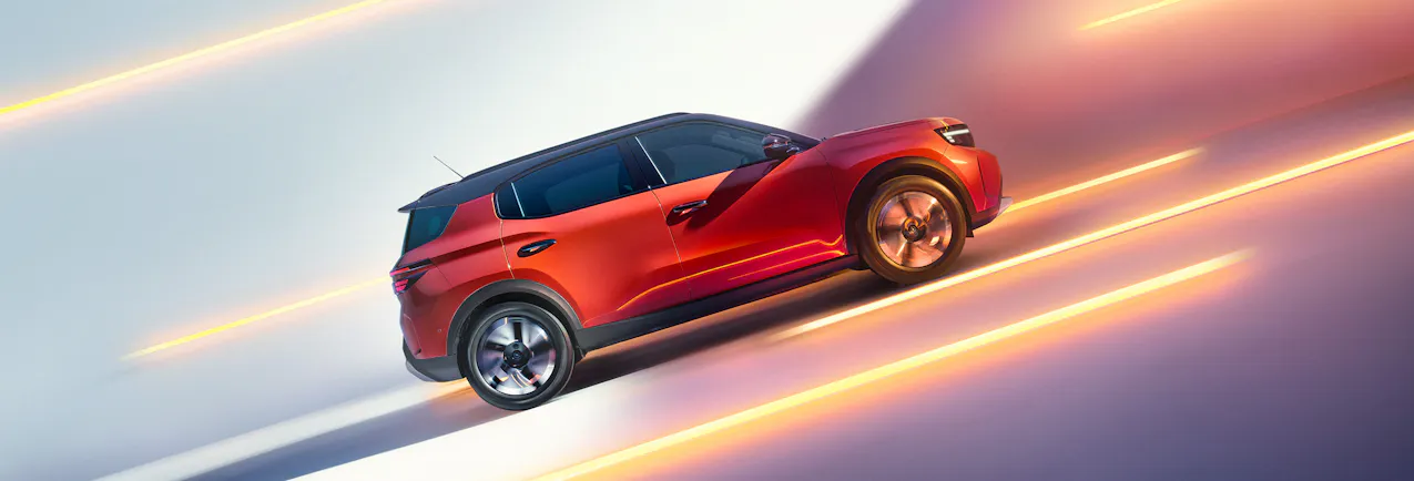 Opel Frontera Electric arancione, fasci di luce sullo sfondo