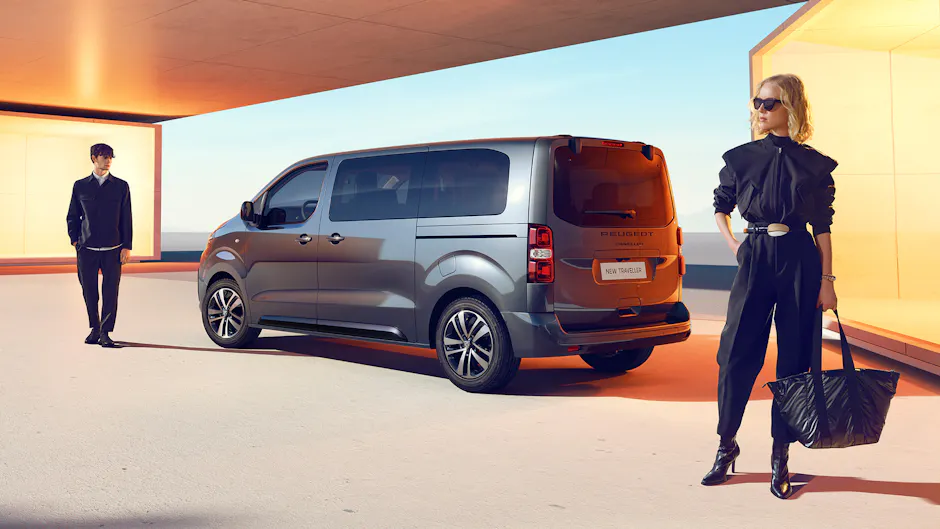 Peugeot Traveller gris de derrière, dame avec sac au premier plan