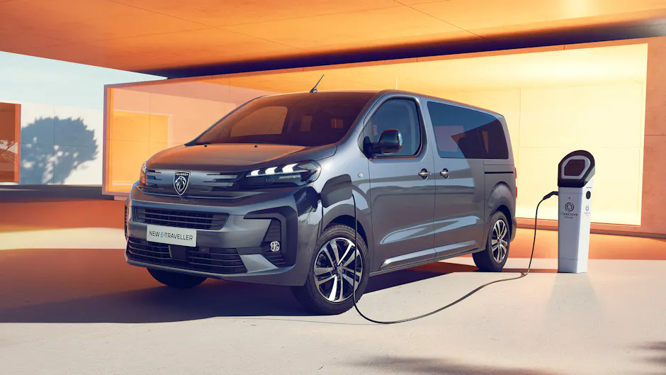 Nouvelle Peugeot E-Traveller en gris près du magasin, garage moderne avec fenêtre orange
