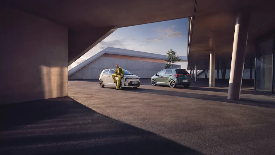 Kia Picanto in bianco e verde accanto a un edificio al tramonto