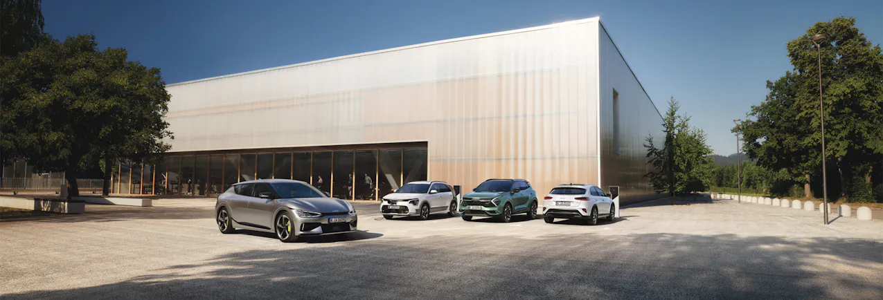 Alle Kia Fahrzeuge vor Industriegebäude, EV6 im Vordergrund