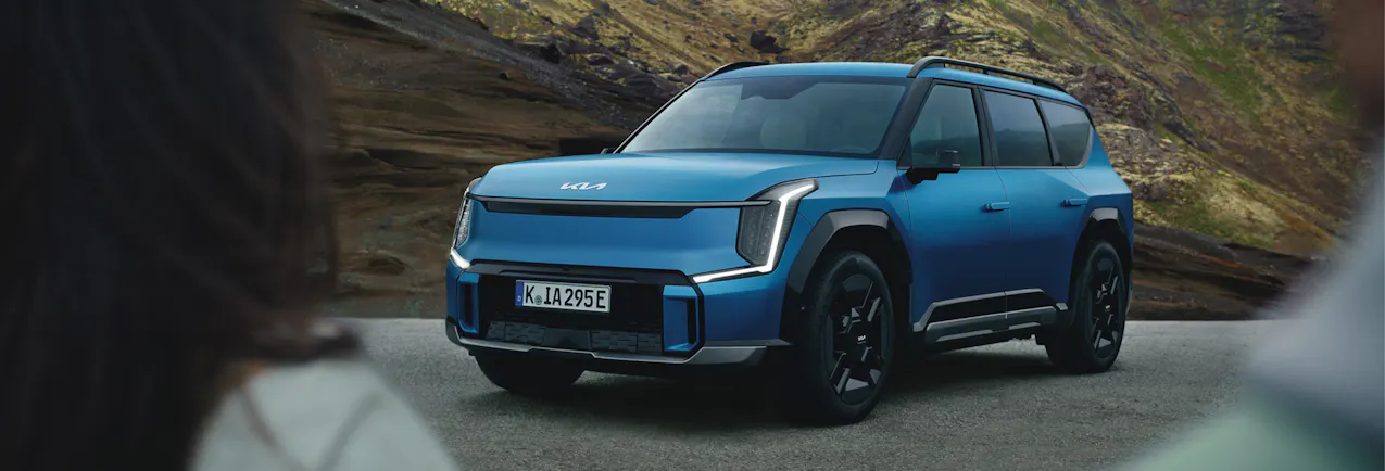 Kia EV9 en bleu, sur une route de col en montagne