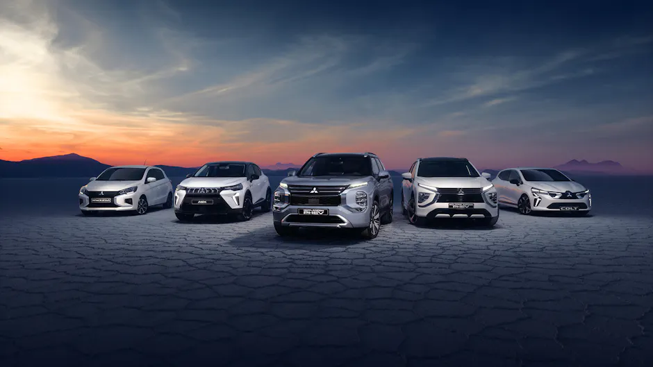 Des modèles Mitsubishi sur un sol craquelé et un coucher de soleil