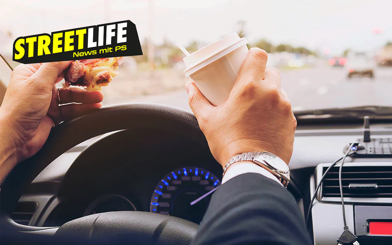 Personne au volant avec de la nourriture et un gobelet de café