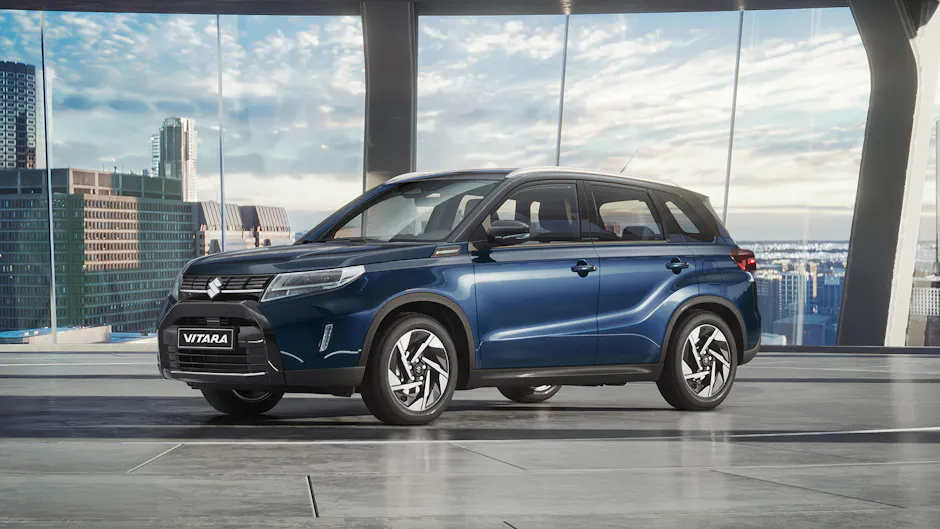 Suzuki Vitara blu con lo skyline sullo sfondo