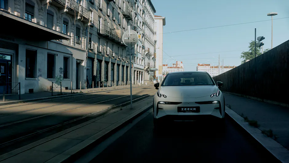 Zeekr X in bianco, attraversa un quartiere cittadino, cielo blu