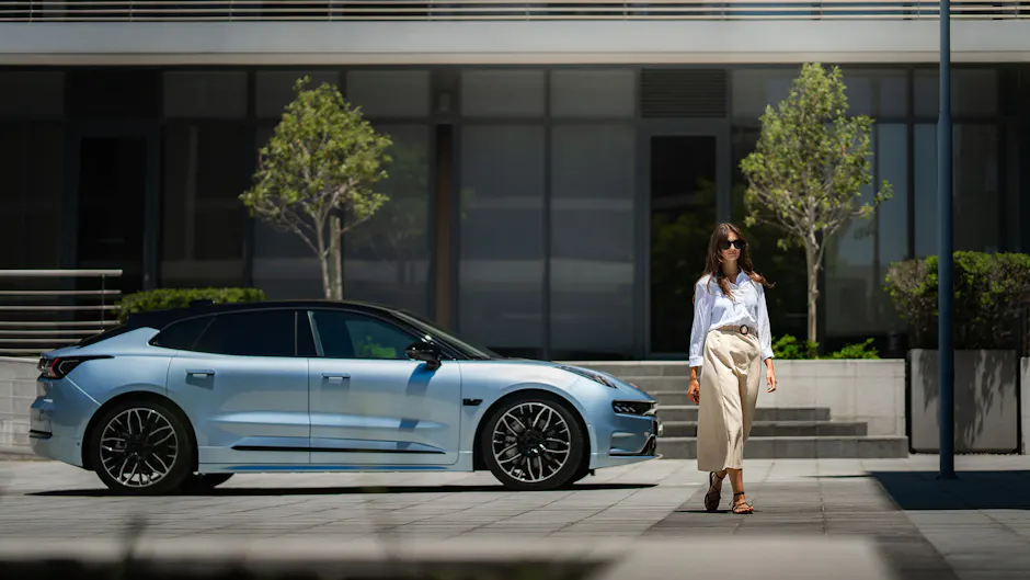Zeekr 001 en bleu électrique vu de côté, une femme s'enfuit