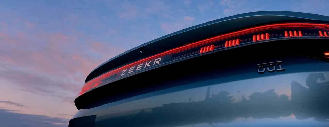 Zeekr 001 in un elegante blu, parte posteriore futuristica, cielo blu con piccole nuvole