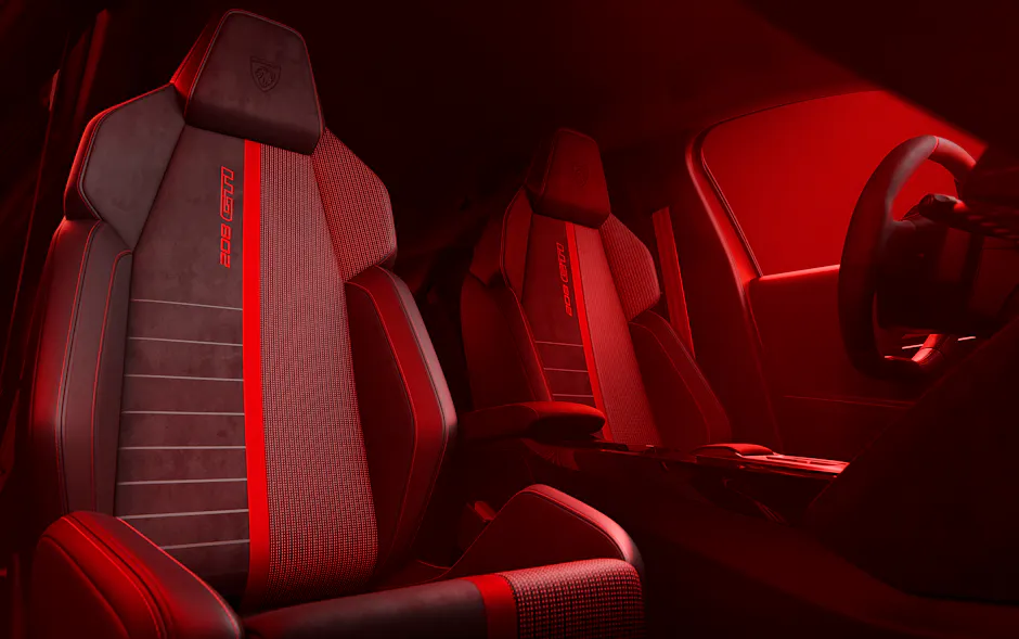 Accents rouges et sièges sport à l’intérieur de la PEUGEOT E-208 GTi