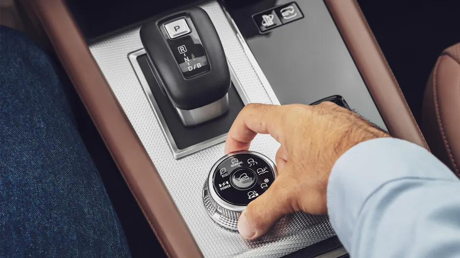 Un homme modifie le mode de conduite sur la console centrale d'une Mitsubishi