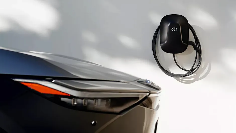 Una parte frontale Toyota nera, una wallbox su una parete bianca