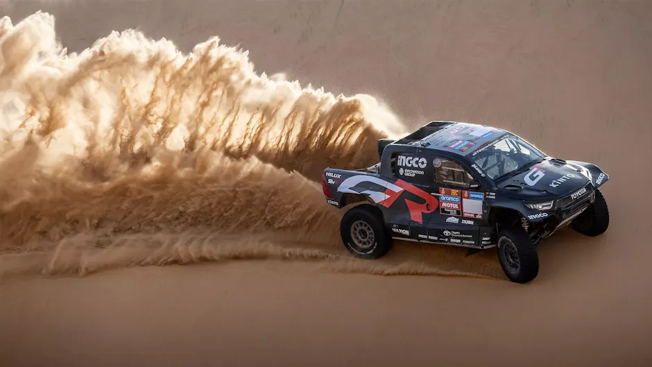 Auto da rally Toyota nera nel deserto, che corre sulla sabbia