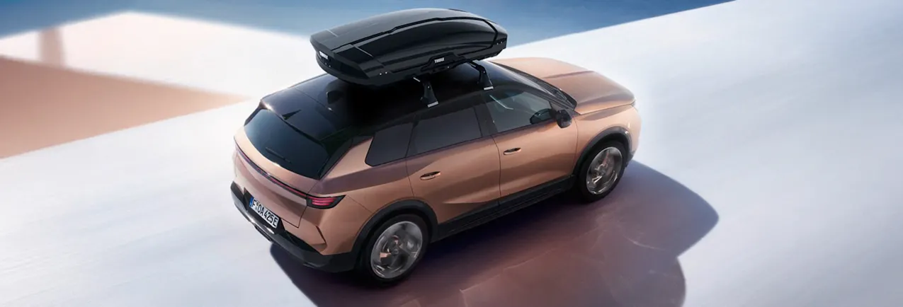 Opel bronzo con un box da tetto nero