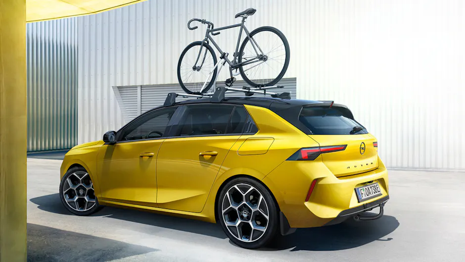 Opel Astra di un bel giallo, con portabiciclette, vista laterale