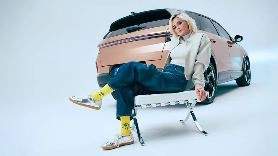 Opel Grandland bronzo visto da dietro, una donna è seduta davanti all’auto