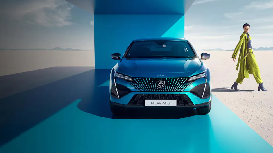 Vue de face d'une Peugeot 408 bleue sous un auvent bleu moderne. À droite de l'image, une femme vêtue d'une tenue vert vif et de chaussures à talons hauts traverse un vaste paysage lumineux.