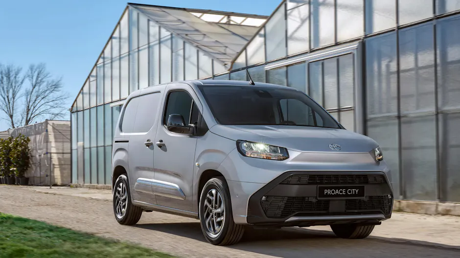 Bus Toyota gris devant une serre