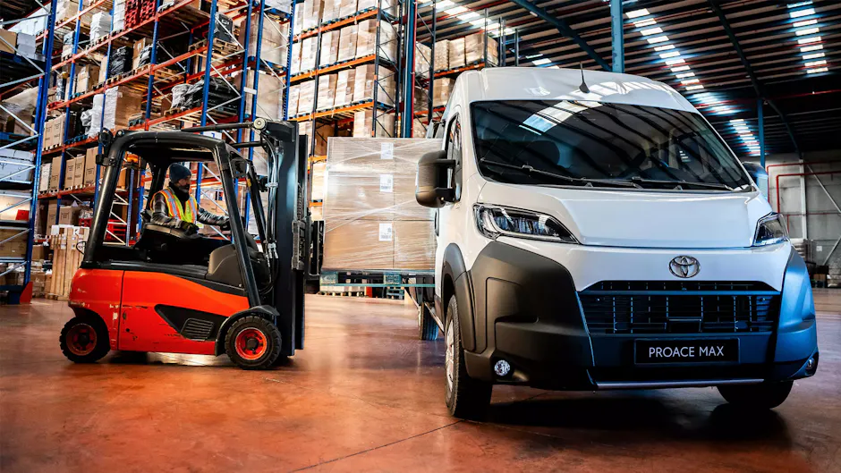 Toyota blanche dans un entrepôt à côté d'un chariot élévateur