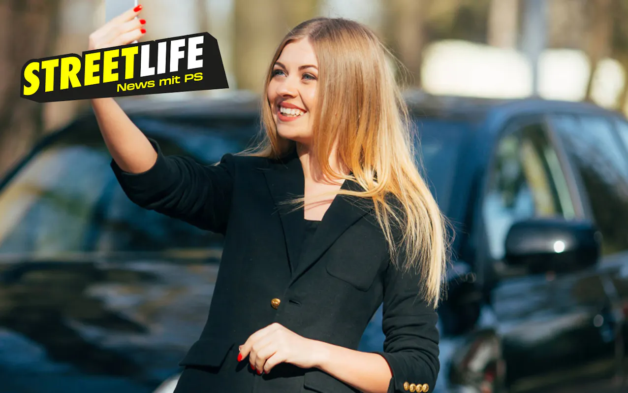 Donna si scatta un selfie davanti a un'auto