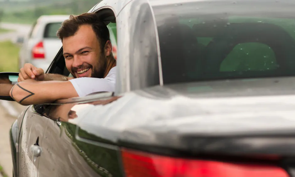 Un uomo guarda fuori dal finestrino dell'auto 