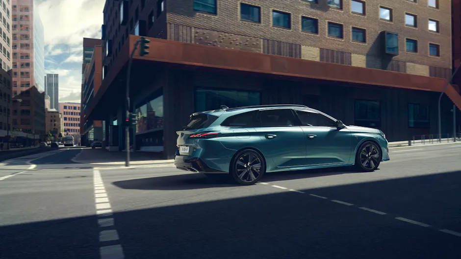 Une Peugeot hybride rechargeable en bleu élégant circule dans un environnement urbain 