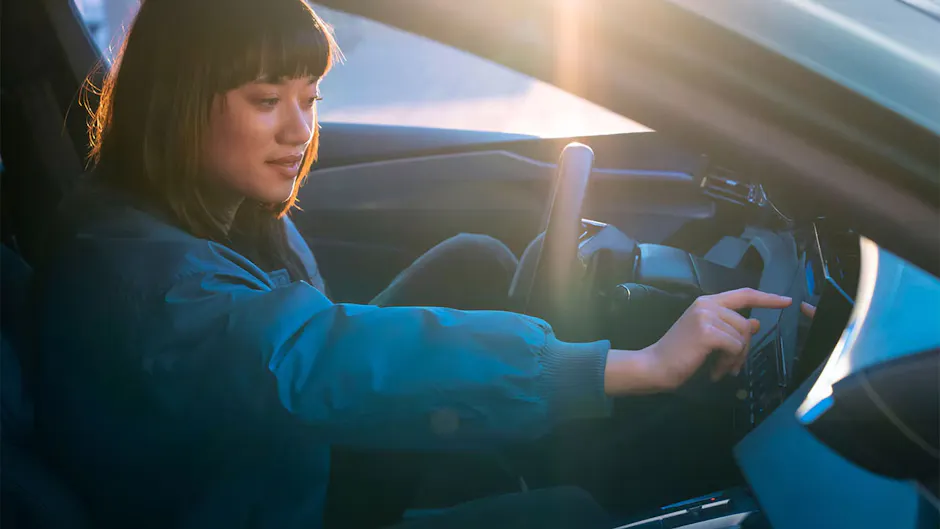 Une femme utilise l’écran numérique dans la console centrale d’une Peugeot