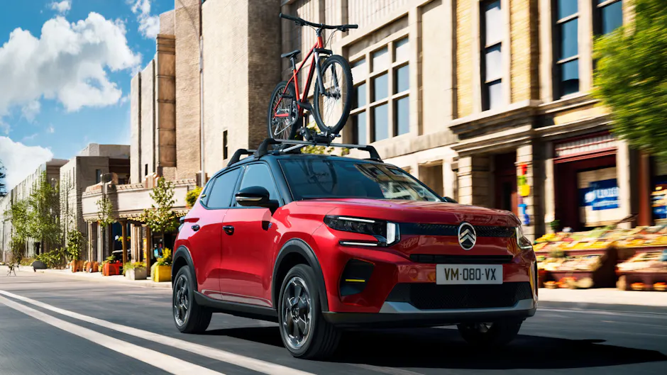 Citroën rouge avec vélo rouge sur le toit 