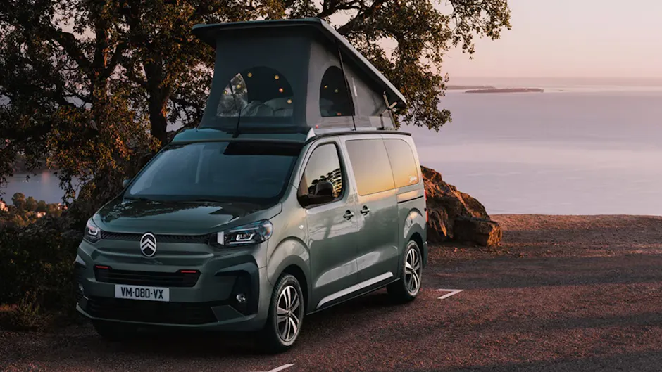 Citroen Camper mit Zelt auf dem Dach, im Hintergrund Aussicht aufs Meer