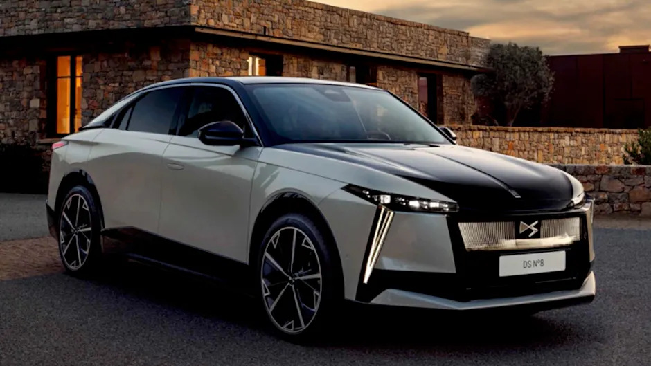 DS Automobiles N8 in argento vista di fronte, con una casa in pietra sullo sfondo