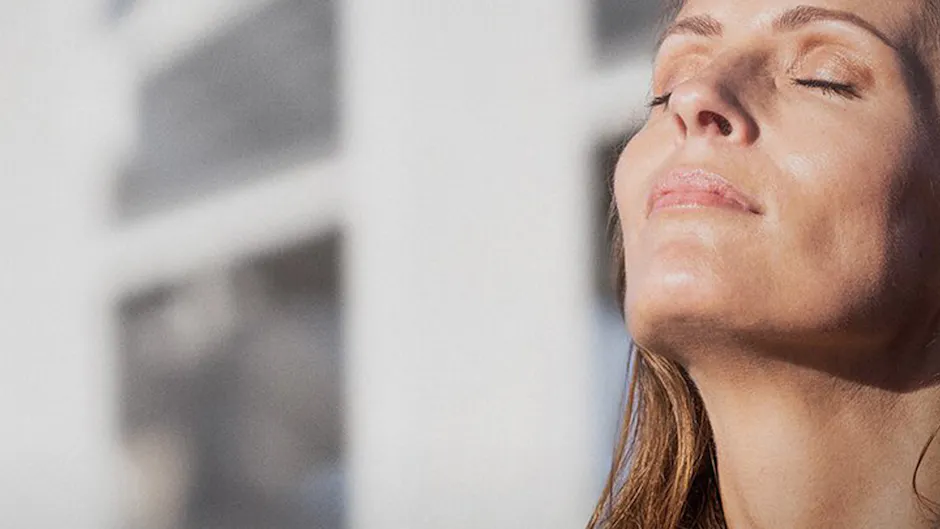 Le soleil brille sur une femme qui a les yeux fermés