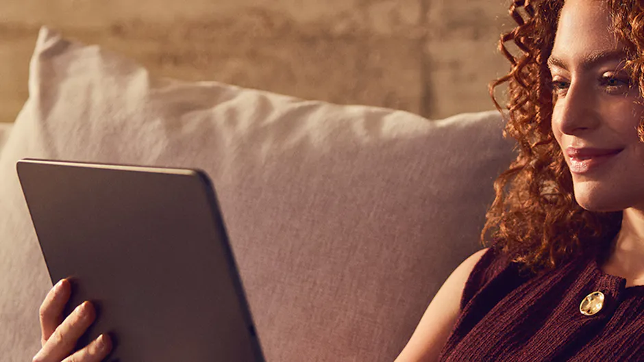 Une femme regarde sa tablette, le soleil lui éclaire le visage