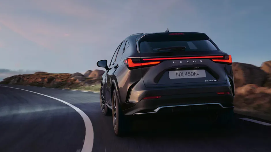 Ein Lexus NX450h+ von hinten, fährt auf einer Strasse