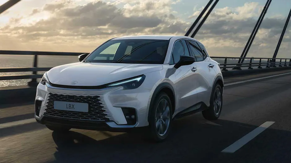 Lexus LBX in Weiss, fährt auf einer Brücke