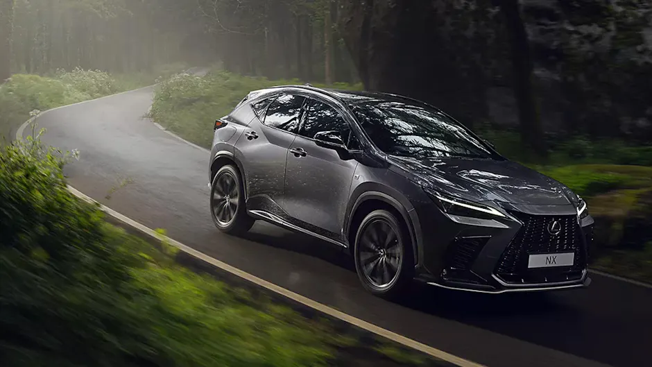 Lexus NX in Grau, fährt auf einer Strasse im Wald