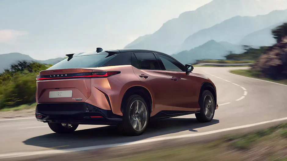 Lexus RZ en Sonic Copper, roulant sur une route sinueuse