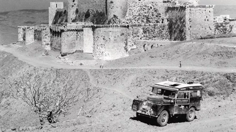 Vecchia Land Rover Defender, sullo sfondo si vede un castello