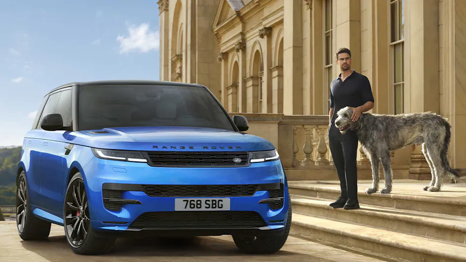 Homme avec chien à côté d'une Range Rover bleue