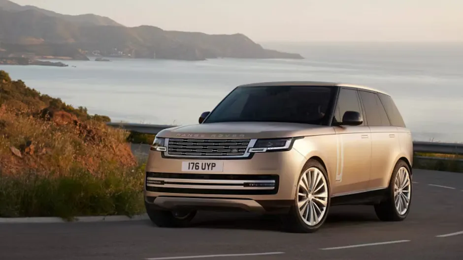 Ein Range Rover fährt einer Küste entlang, das Meer im Hintergrund