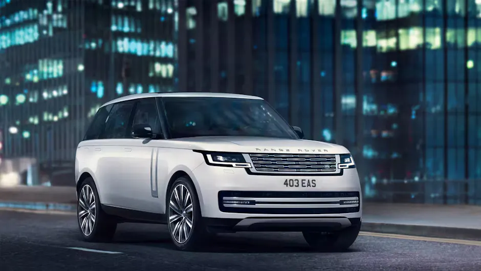 Una Range Rover bianca sulla strada, sullo sfondo un grattacielo