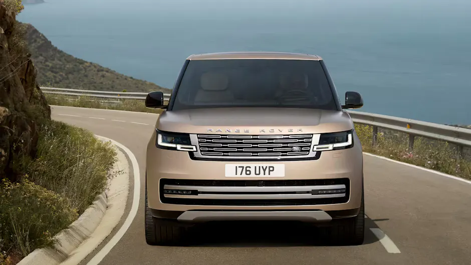 Range Rover auf einer Küstenstrasse, im Hintergrund das Meer
