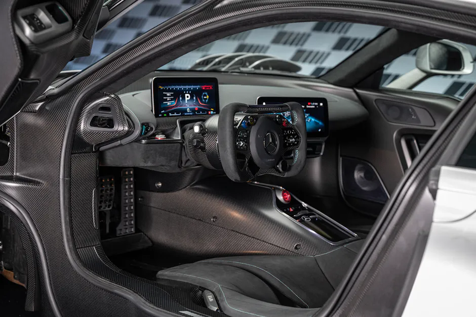 Interni della Mercedes-AMG One con volante rettangolare in stile F1, display digitali e abitacolo in fibra di carbonio.