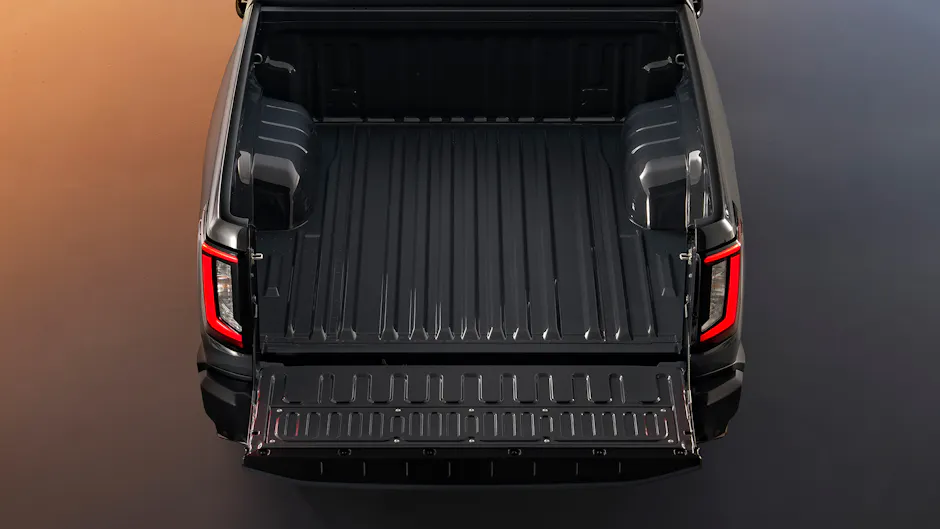 Offene Ladefläche des Toyota Hilux BEV mit robustem Stahlboden und LED-Rückleuchten.